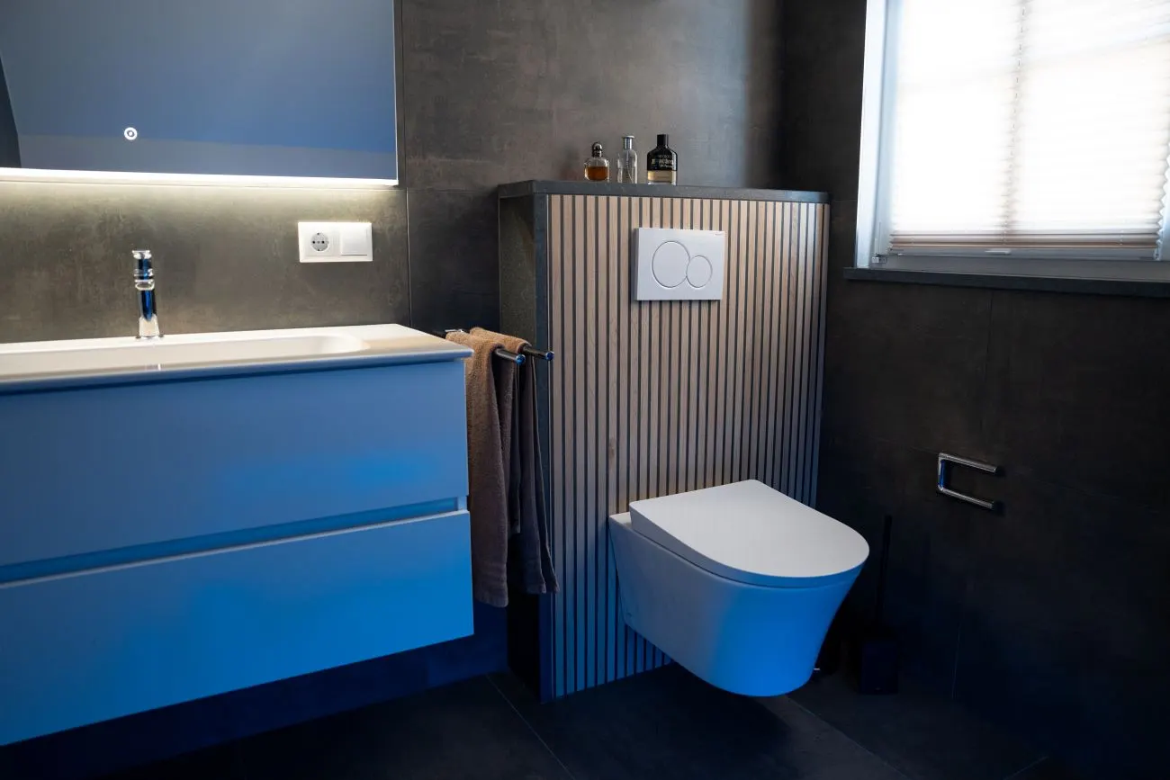 Badezimmer mit stilvoller Wandverkleidung und schwebendem WC